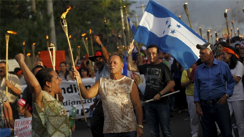 People take part in a march to demand the resignation of Honduras' President